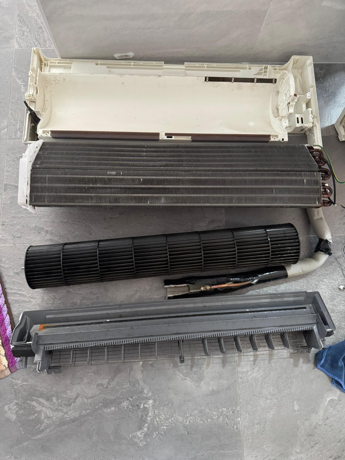 Aircon evaporator coil during a chemical wash, showing the indoor fan coil and drainage tray