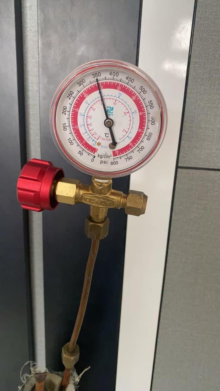 Pressure gauge connected to the service valve of an aircon system during a leak check
