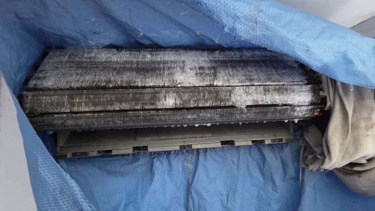 The same aircon wrapped in a wash bag so the coil can be chemically washed while it stays mounted on the wall