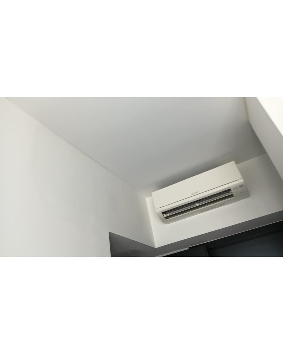 The finished wall after relocation, with the aircon unit in its new position and no trace of the old mounting point