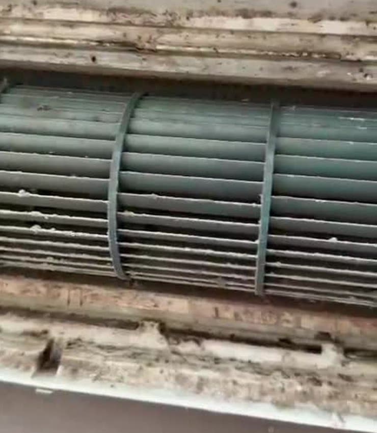 Mould and grime around the blower wheel and air outlet of a wall-mounted aircon