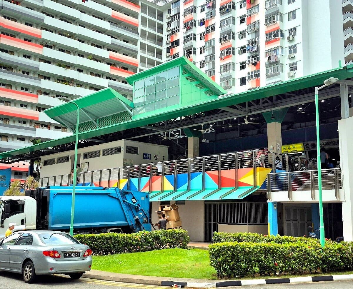 Neighbourhood market and cooked food centre beneath colourful HDB blocks in Geylang, Singapore